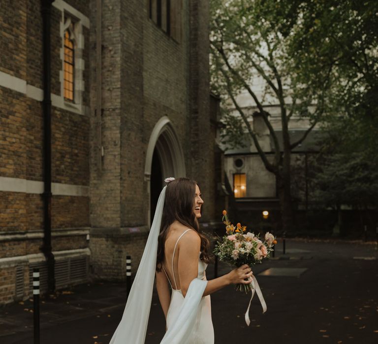 Stylish bride in slip wedding dress at church micro wedding 