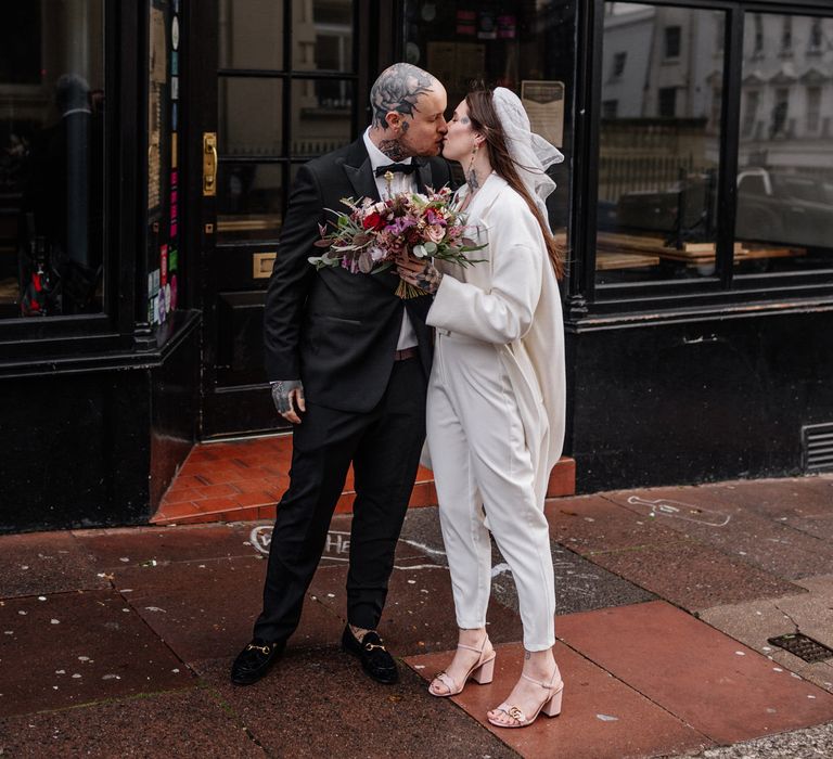 Alternative bride and groom in tuxedo and jumpsuit 