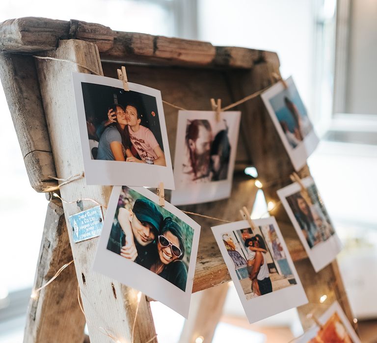 Polaroids pegged to a ladder for budget wedding decor