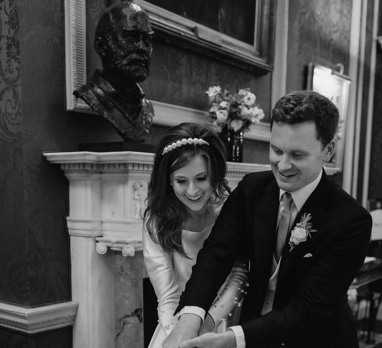 Bride and groom cutting wedding cake at Royal Automobile Club Wedding 