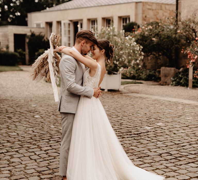 Bride and groom embrace in castle gardens