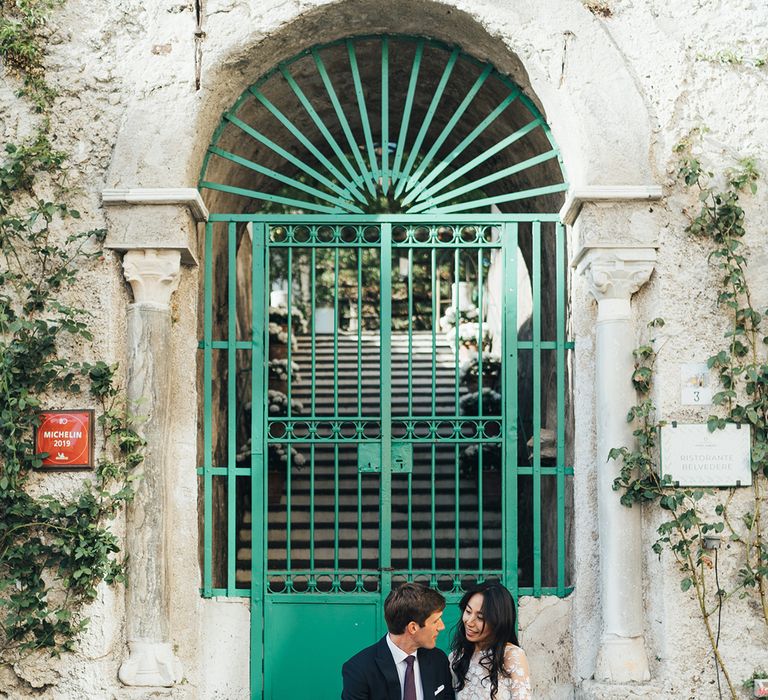 Bride and groom portrait sitting on the steps at their Villa Cimbrone destination wedding in Ravello, Italy