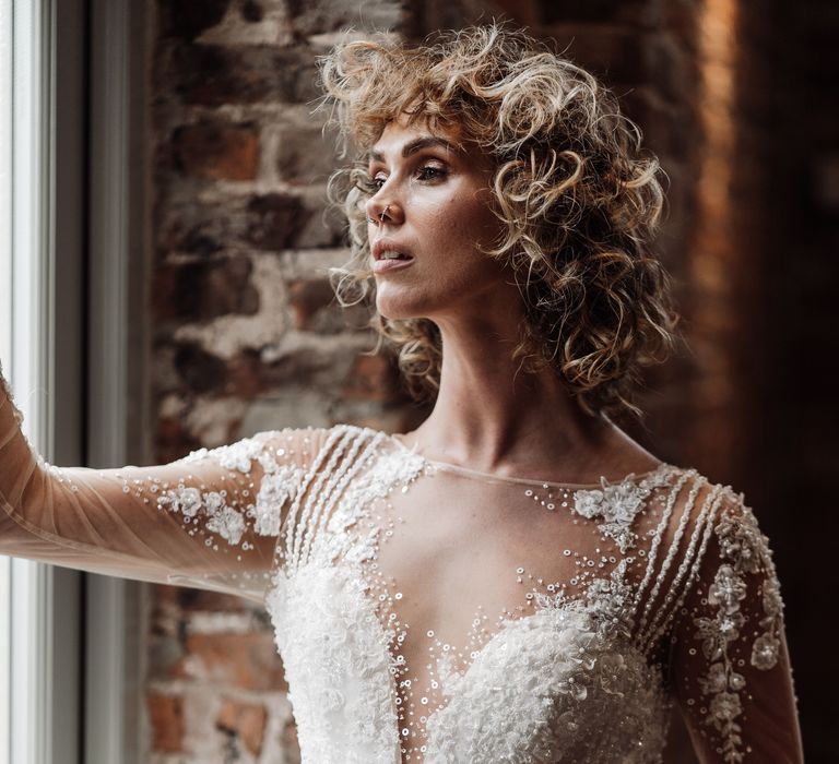 Bride with short curly wedding hair in front of the exposed brick wall barn at Sedgewell Barn