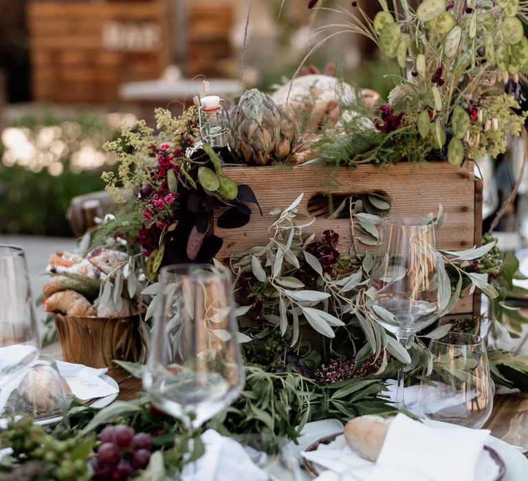 Crate centrepiece decor with foliage, fruits and flowers 