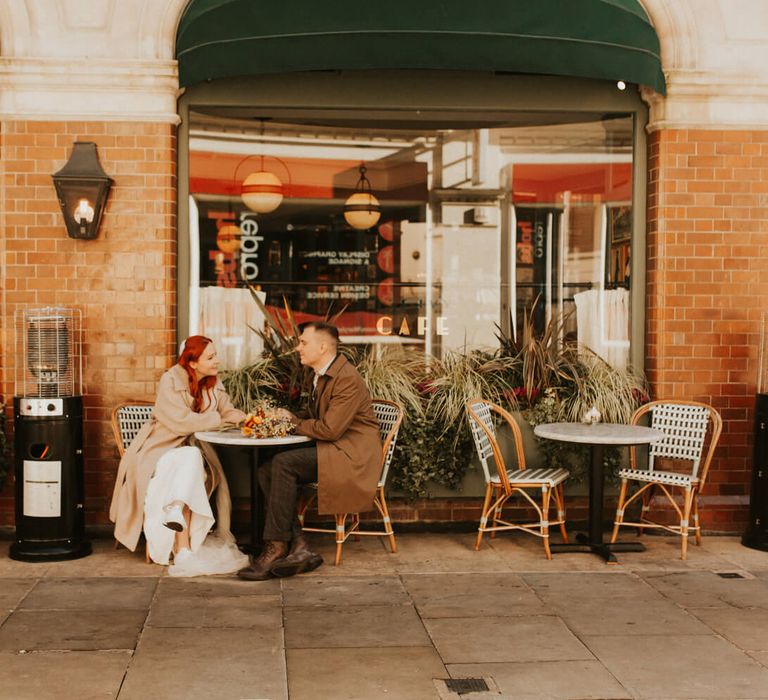 Bride and groom sat outside London café for city elopement 