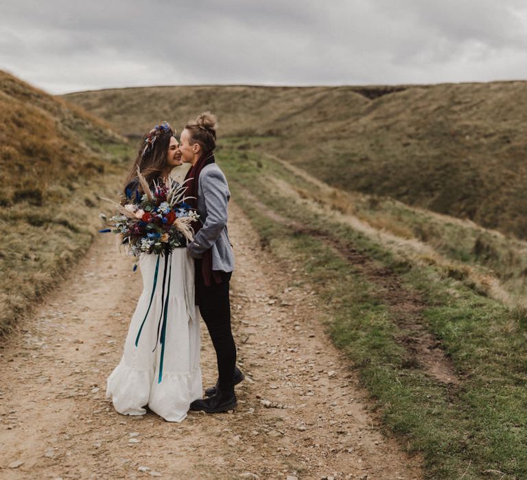 The brides hugging and smiling on the Peak District moors