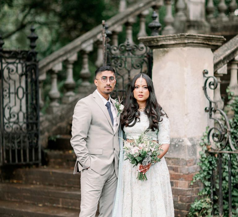 Beautiful Sikh interfaith wedding with groom in a beige suit and bride in a pastel green and white embroidered separates