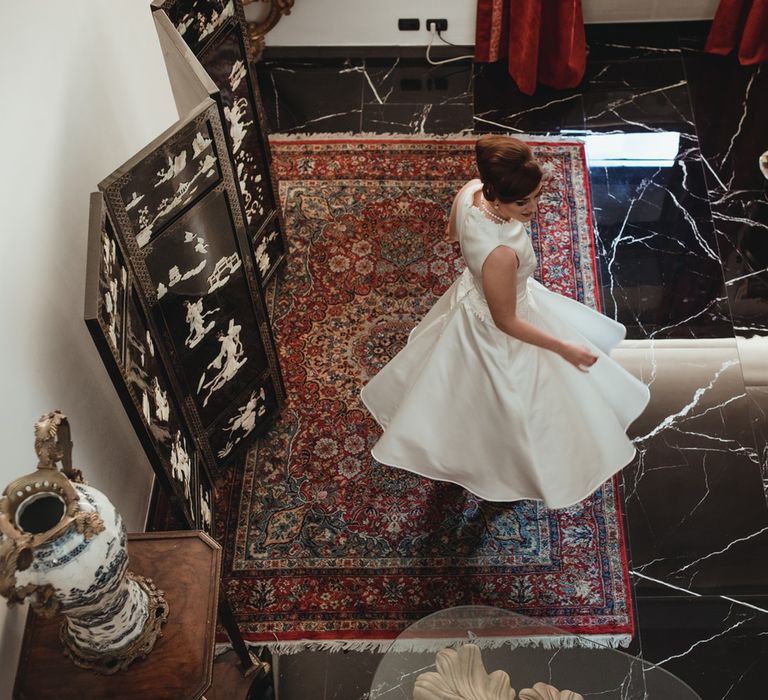 The bride seen from above, twirling in her vintage style wedding dress