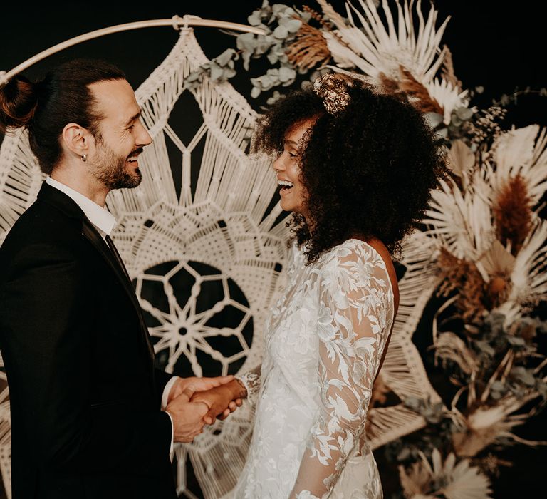 Bride & groom during ceremony standing in front of Macrame centrepiece 