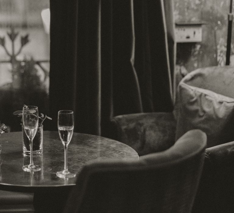 Black & white image of two glasses of champagne on table