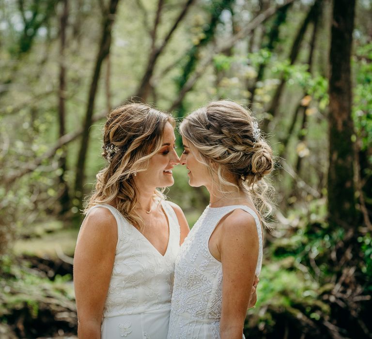 Brides look lovingly at one another and wear their hair in boho chic styling on their wedding day