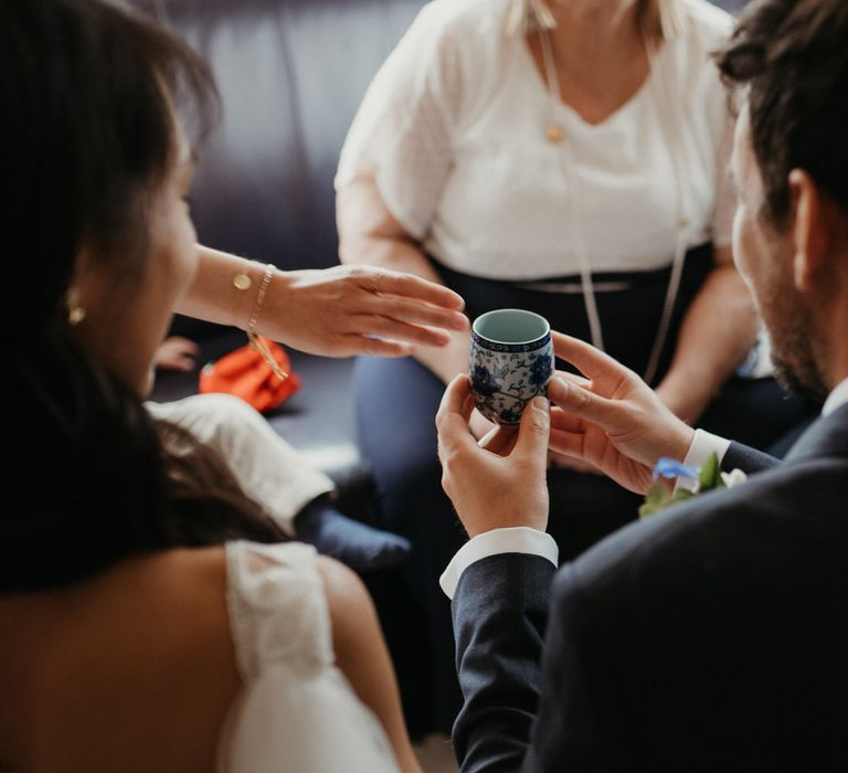 Groom holding a drinking cup at Chinese tea ceremony 