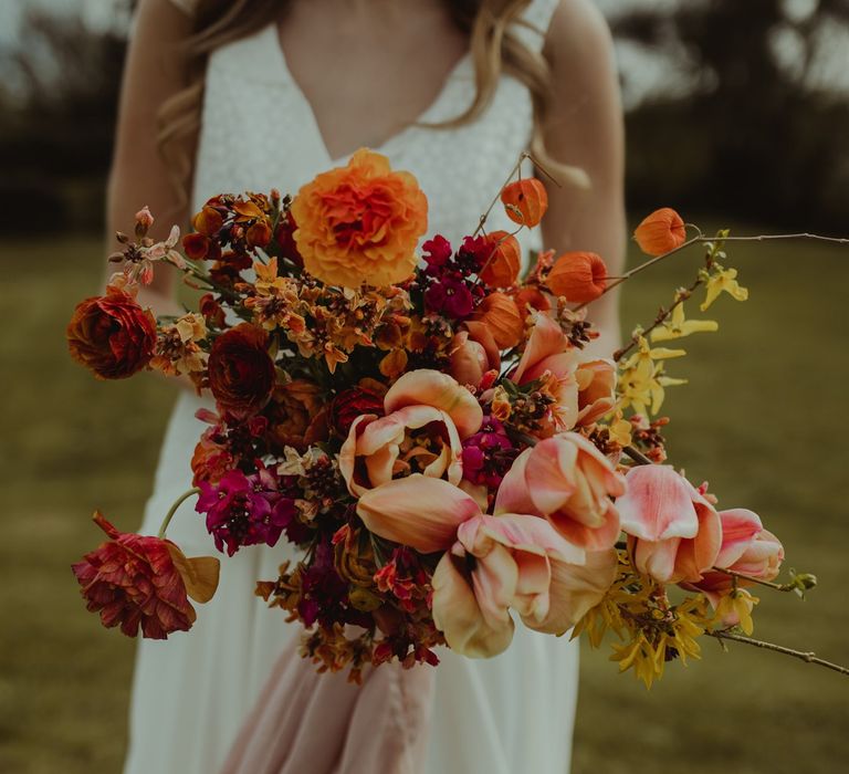 Stunning large wedding bouquet in oranges, pinks and reds