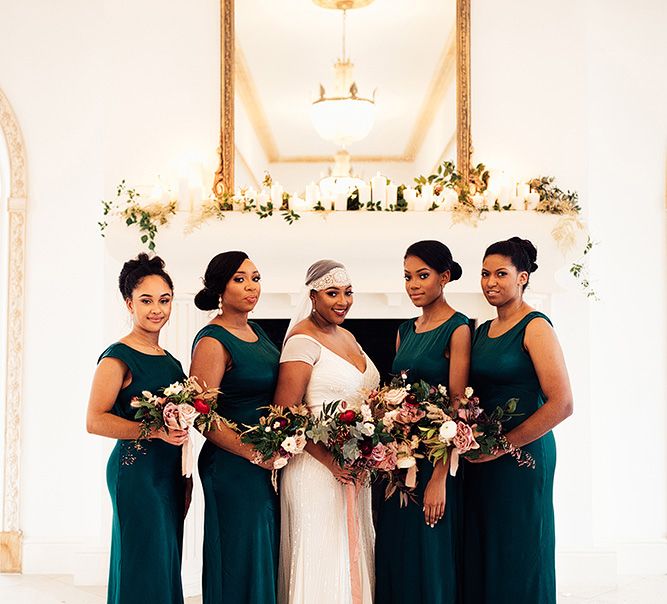 Bridesmaids in dark green satin bridesmaid dresses and bride in a Juliet cap veil 