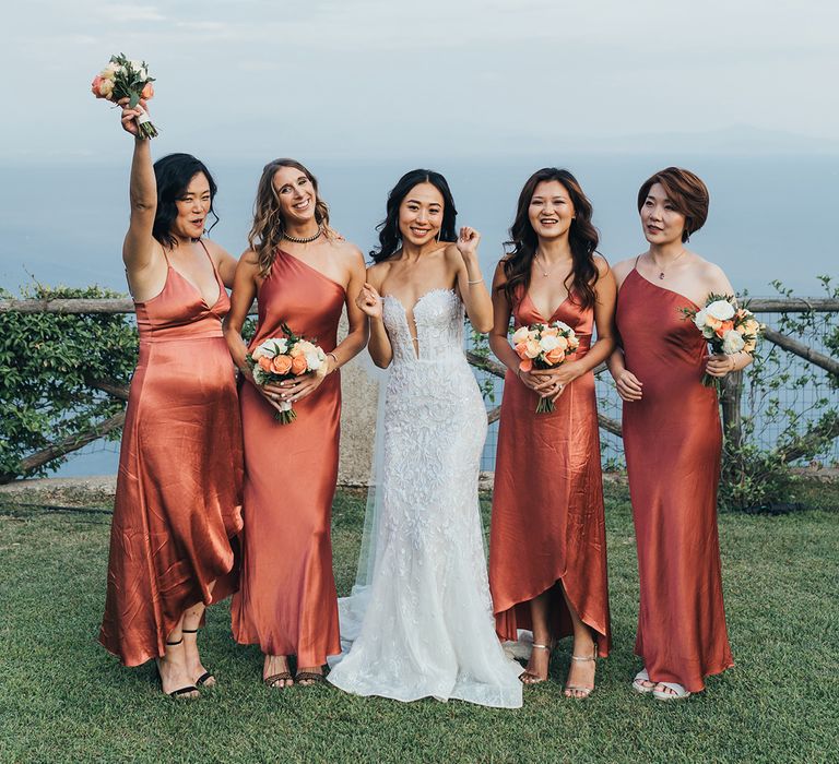 Ravelo wedding with bridesmaids in different coral/orange satin bridesmaid dresses 