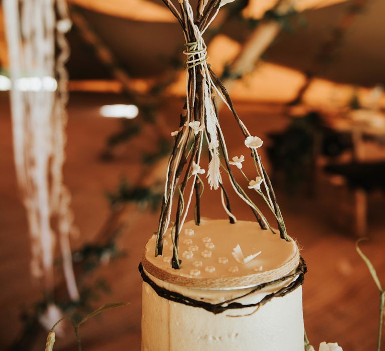 Outdoor rustic wedding with boho decor including a naked tipi wedding cake topper 