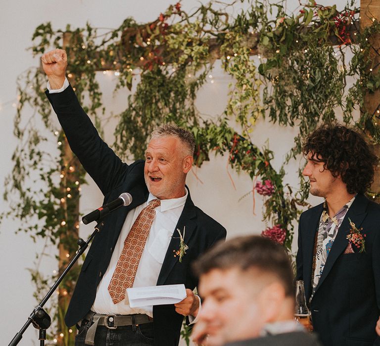 Wedding guest holds up a glass on wedding day