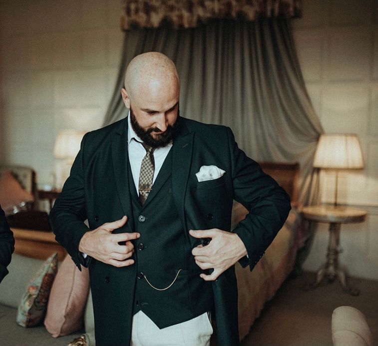 Groom wears deep green blazer and waistcoat on the day of his wedding