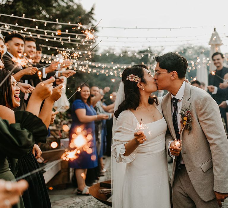 Bride & groom kiss during sparkler exit on their wedding day