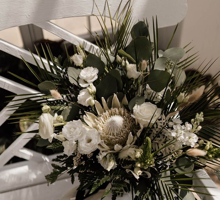 white wedding bouquet with king protea, stocks, roses, ranunculus and bunny ears