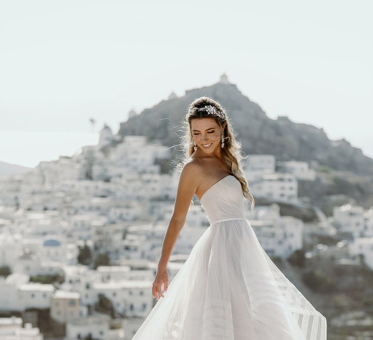 Bride wears full Watters wedding gown as she stands outdoors in Greece 