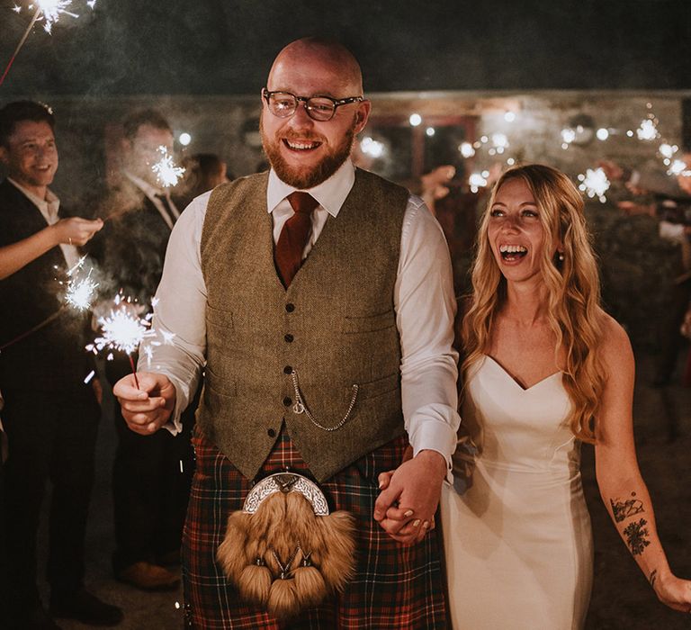 Bride & groom during sparkler exit outdoors during wedding reception