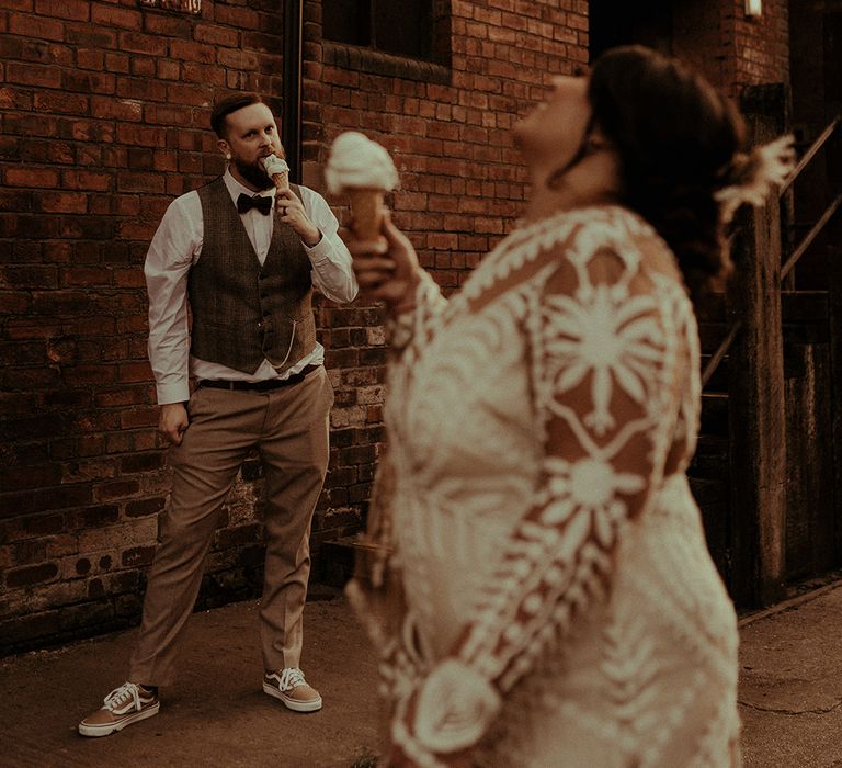 Bride and groom eating ice-creams outside their Victoria Warehouse wedding venue in Manchester 