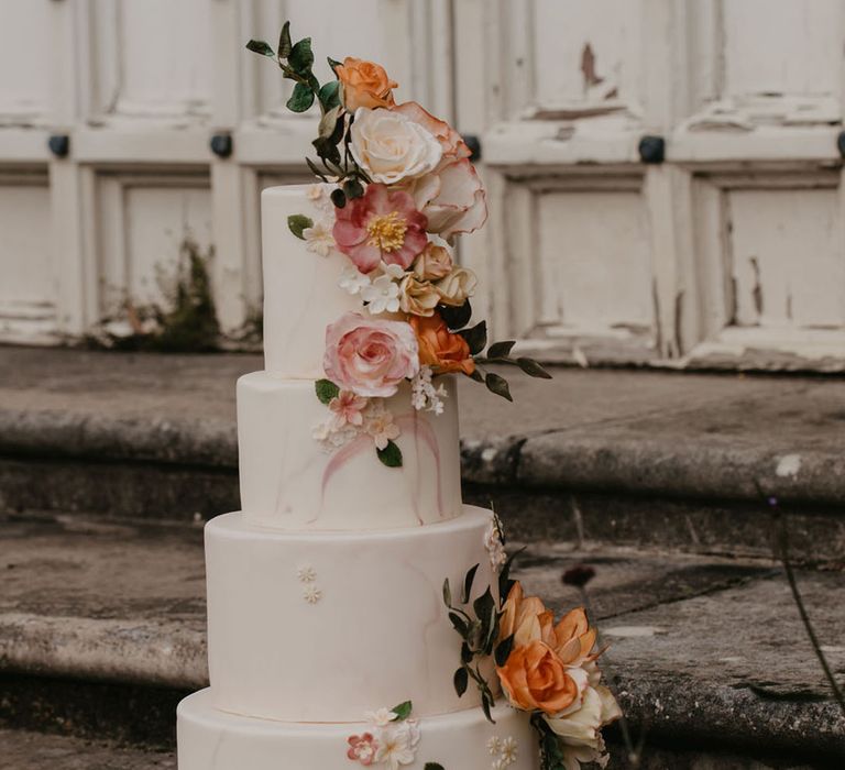 Four tier iced marble wedding cake with sugar flower decoration 