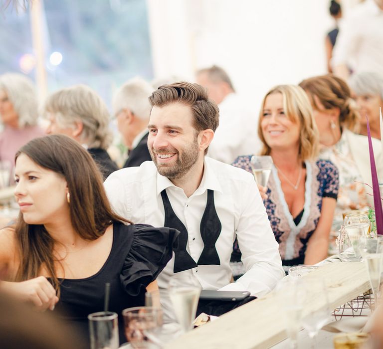 Guests enjoy wedding speeches at marquee wedding