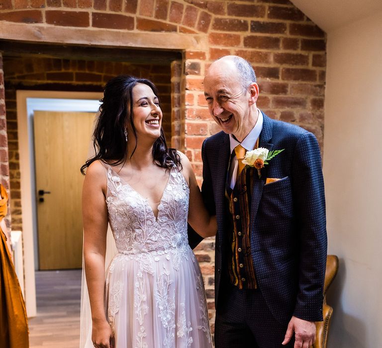 Bride in v-neck illusion lace floral tulle wedding dress with father in patterned blue suit with yellow tie and fun yellow waistcoat