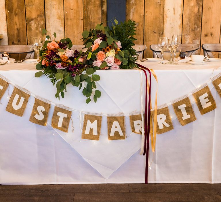 Woven 'Just Married' bunting across the top table with the bride's wedding bouquets