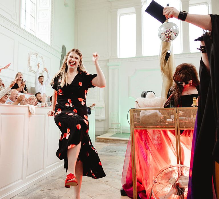 Wedding guest dances while other guests sit and clap along 