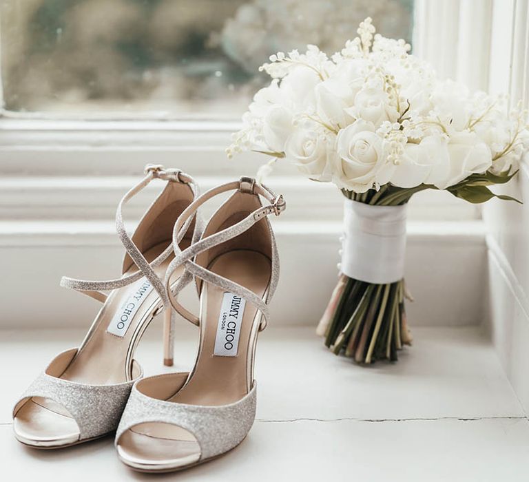 Jimmy Choo wedding shoes next to white wedding bouquet of roses 