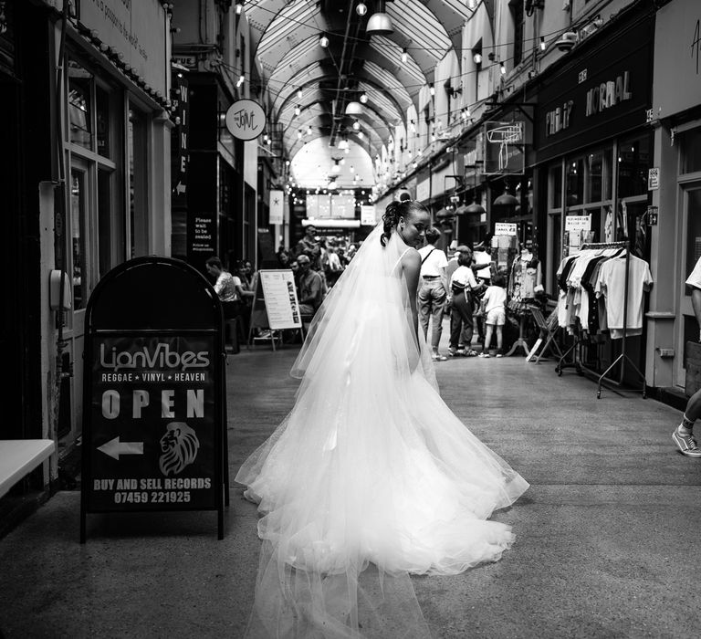 Bride walks through Brixton in sparkly wedding dress in black and white image