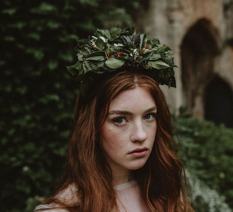 Bride with long wavy red hair and natural makeup wearing a green foliage flower crown 