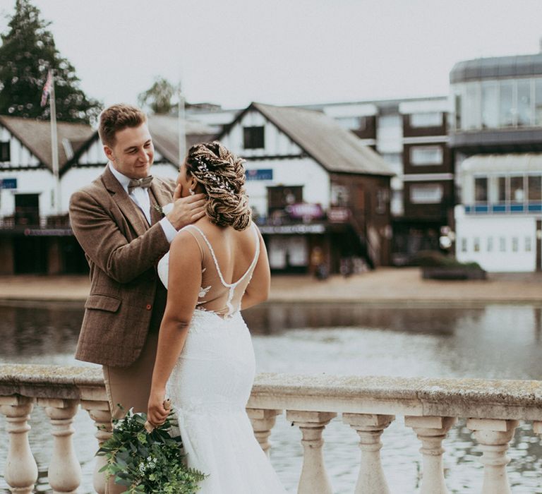 Bride and groom stand next to a river as they have a classic wedding at the Bedford Swan Hotel 