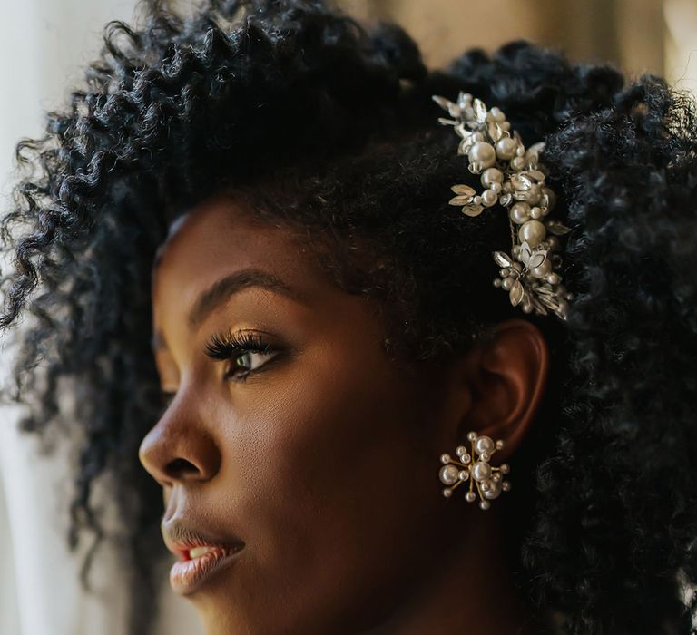 Black bride with shiny pearl hair accessory and earrings 