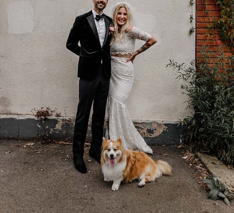 Bride in boho two piece lace bridal outfit and groom in black tux with velvet look bow tie embracing and smiling