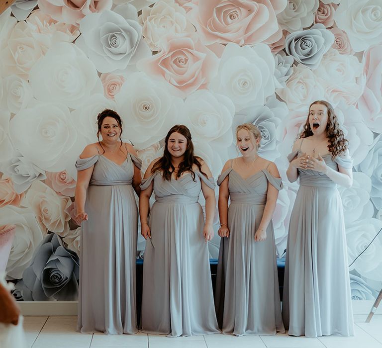 Bridesmaids in grey off the shoulder dress get their first look at the bride in a strapless flower wedding dress 