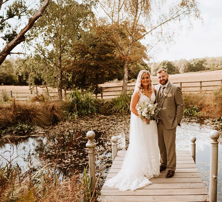 The happy couple pose together outdoors at The Oak Barn for their couple portraits 