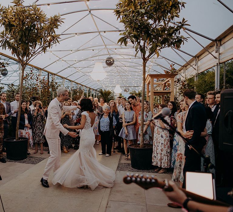 Bride and Groom having their first dance to a live singer while guests are watching