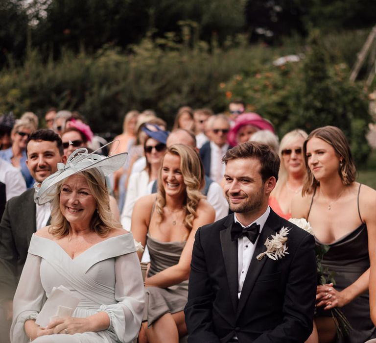 Black tie boho wedding with wedding guests in dark tones surrounded by dried flowers 