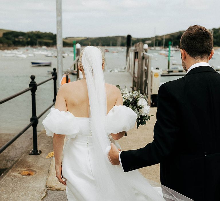 Bride wears floor-length veil in her blonde hair worn in a bun