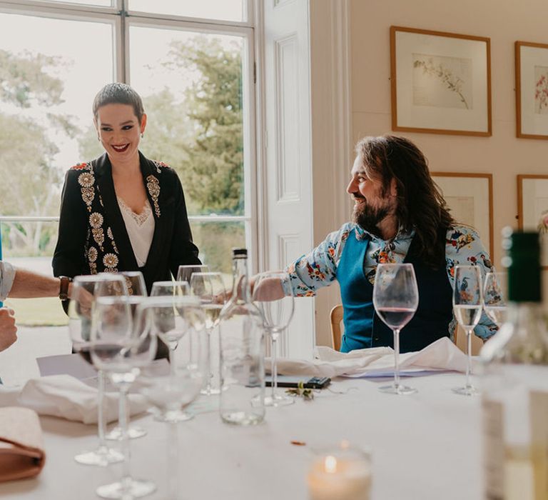 Wedding guests and grooms listen during intimate speeches 