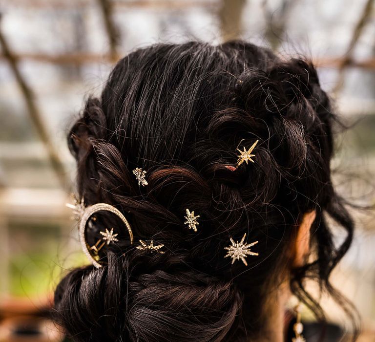 Bride wears gold embellished celestial styled hair accessories 