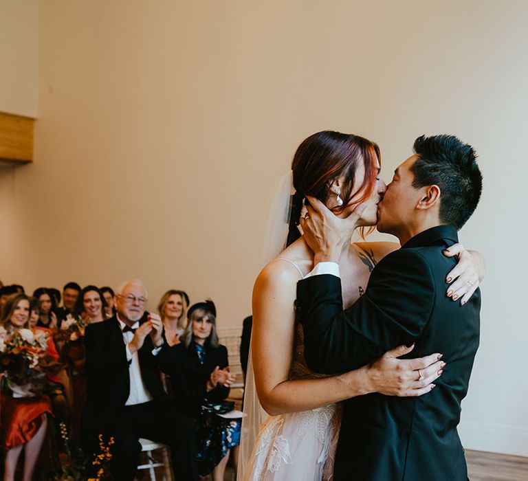 Bride & groom kiss during wedding ceremony with personal vows 