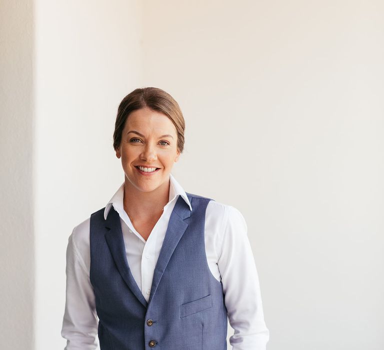 Bride wears white shirt and blue waistcoat 