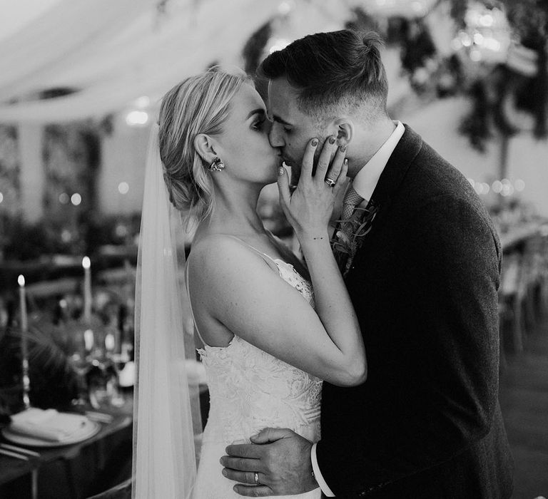 The bride and groom share a kiss together at their botanical greenery theme wedding at Iscoyd Park 