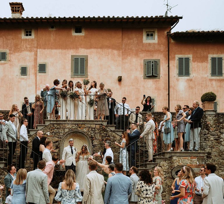 Group photo with bride, groom and wedding guests and confetti shot at Italian villa wedding in Tuscany