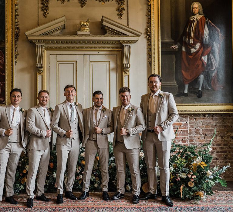 The groom and groomsmen in matching houndstooth suits with different ties for the modern British wedding day 